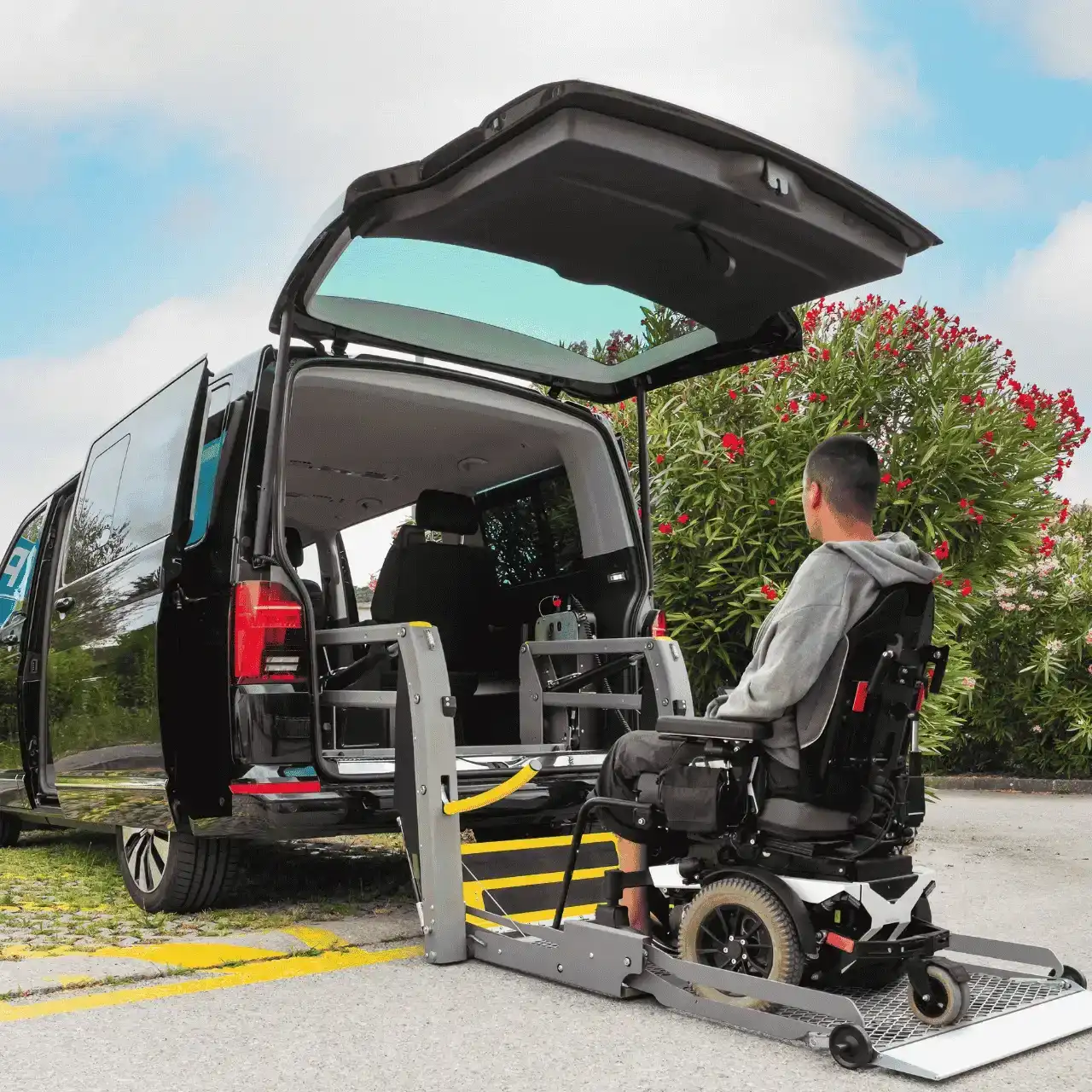 Disabled man in wheelchair using lift to get into disability van
