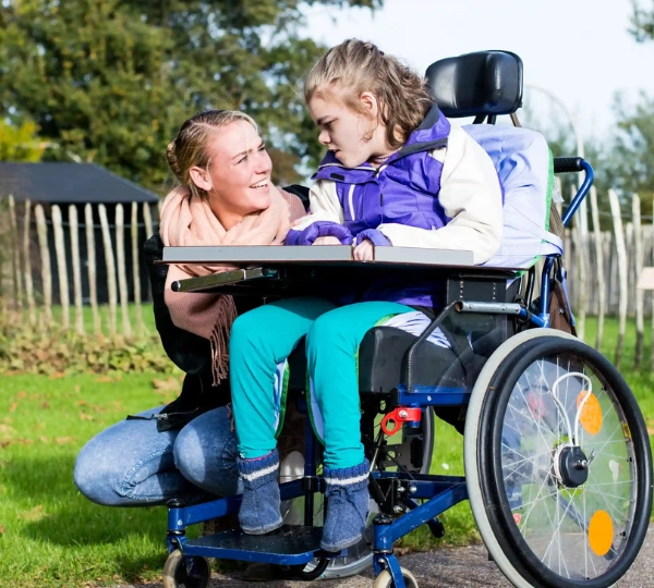 Support worker talking with disabled girl in wheelchair